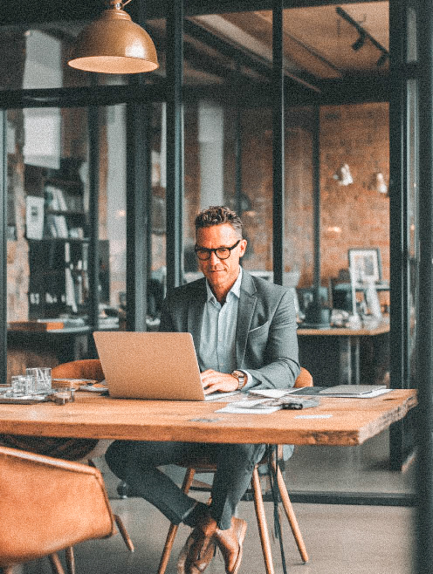 A person working on a laptop at a well-lit desk